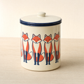 Cream enamel storage tin with a navy rim, printed with a band of standing foxes