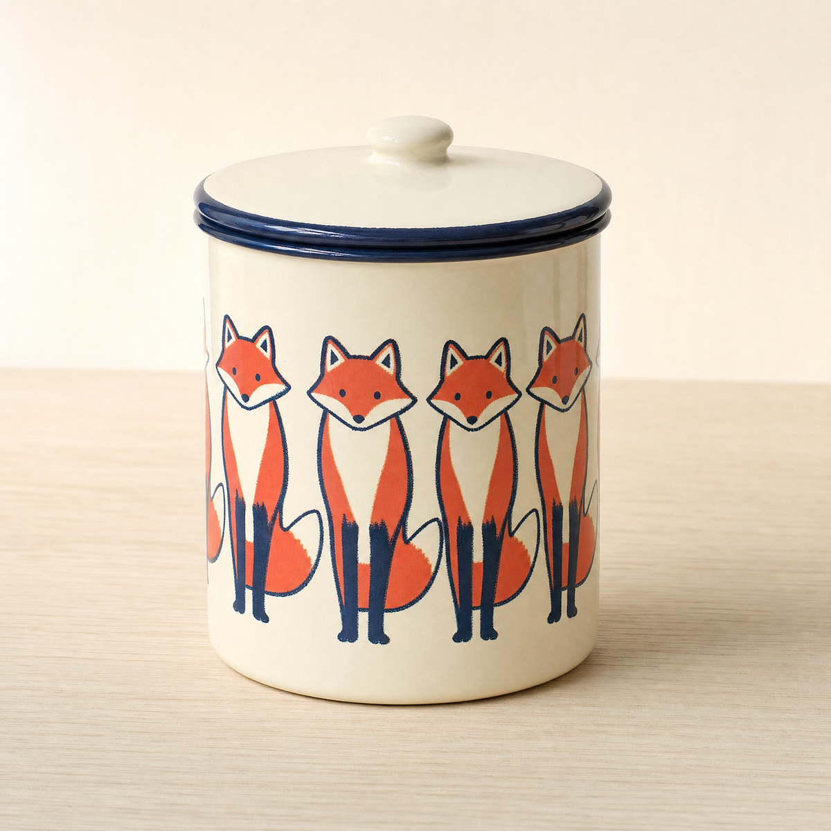 Cream enamel storage tin with a navy rim, printed with a band of standing foxes