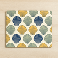 Glass worktop saver printed with repeating scallop shells in navy, sage and ochre